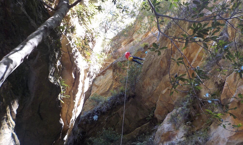 woman abseils down cliff