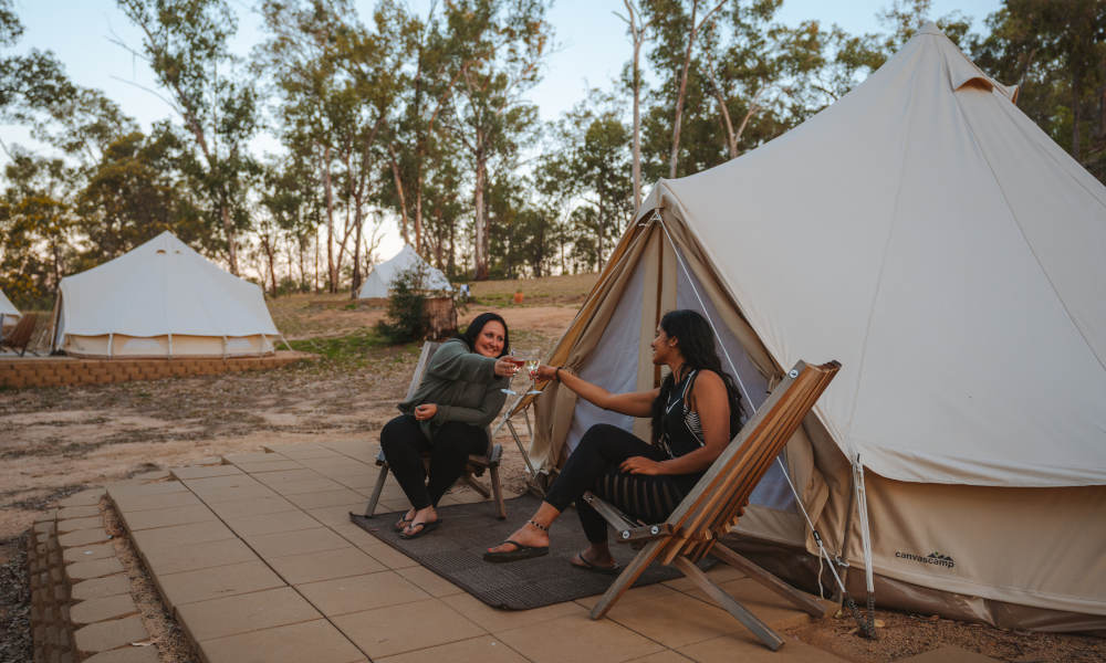 sitting and having a drink outside of glamping tent